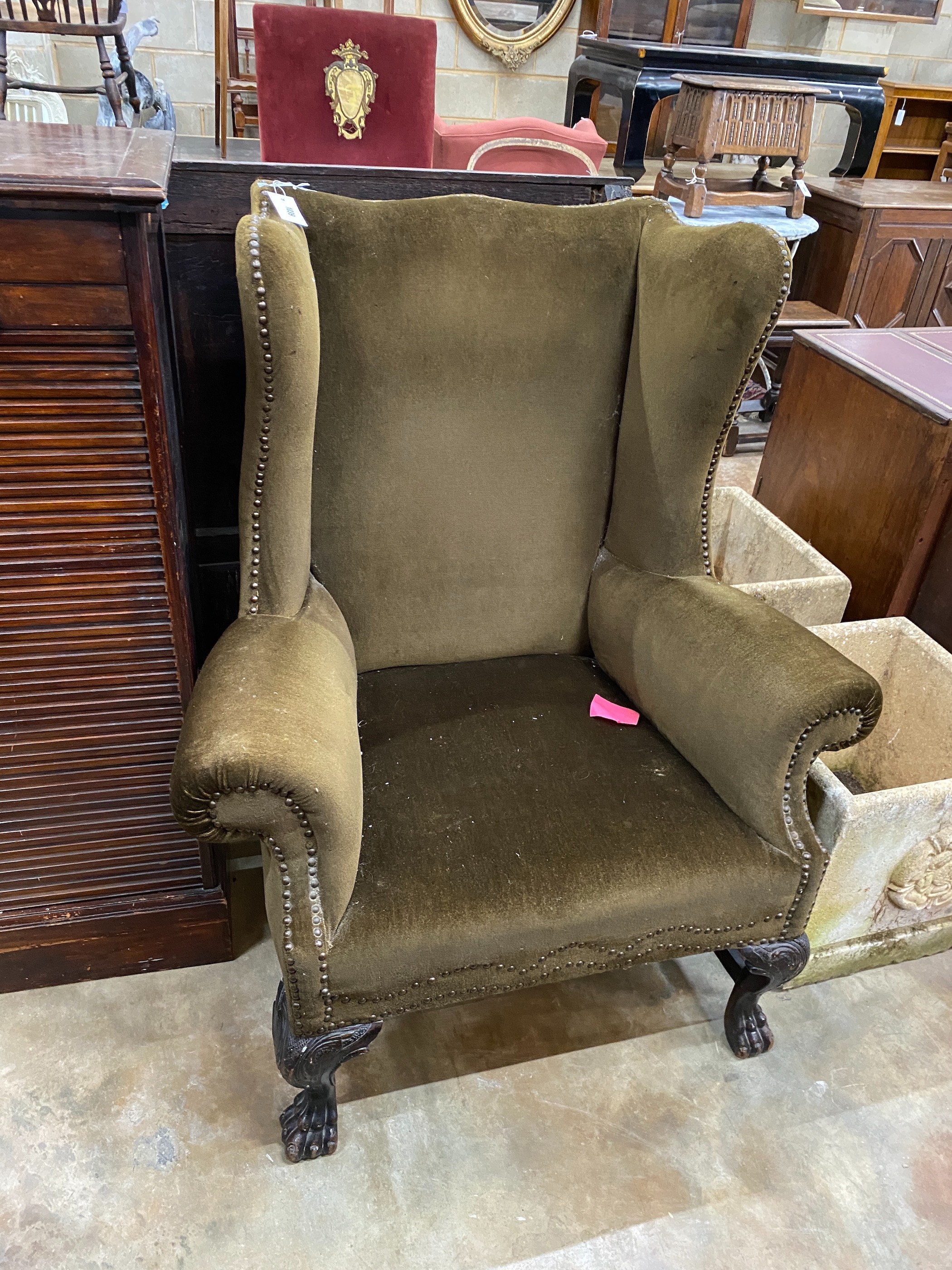An early 20th century Georgian style upholstered wing armchair, width 92cm, depth 68cm, height 110cm